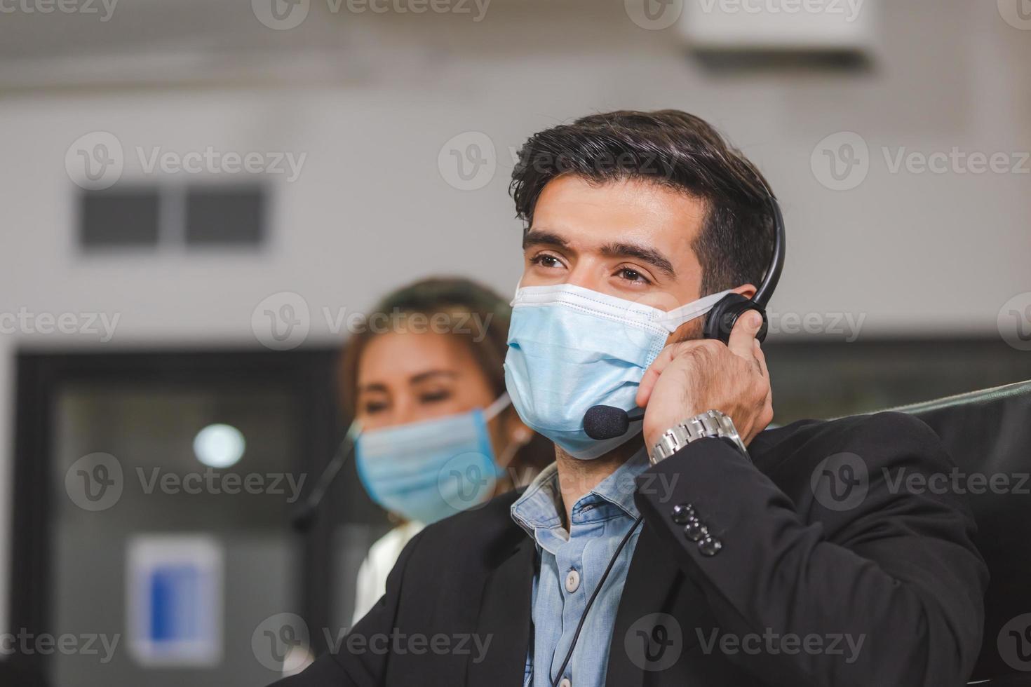 junge telefonistin mit headset-schutzmaske gegen coronavirus, kundendienst-führungsteam, das im büro arbeitet foto