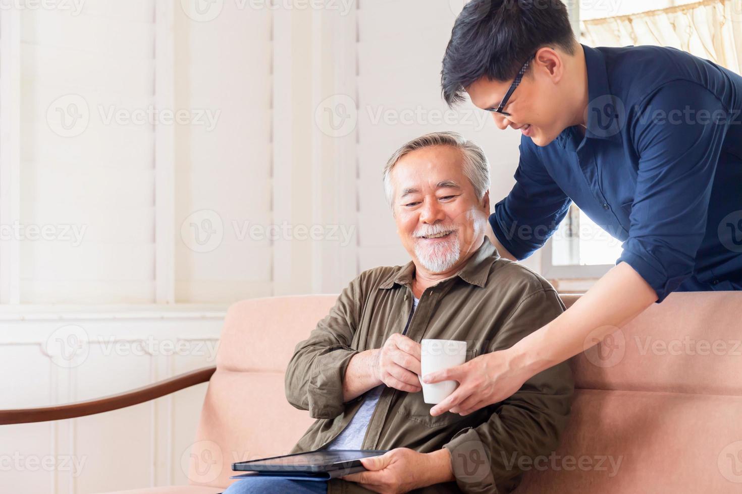 fröhlicher älterer asiatischer vater und sohn mittleren alters im wohnzimmer, glück asiatische familienkonzepte foto