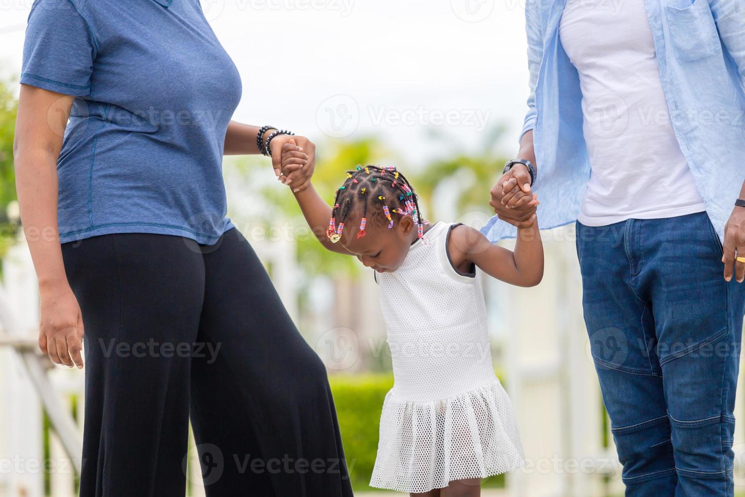 glücklicher vater, mutter und tochter, die zusammen im freien spielen, fröhliche afroamerikanische familie, die im park genießt, glücksfamilienkonzepte foto