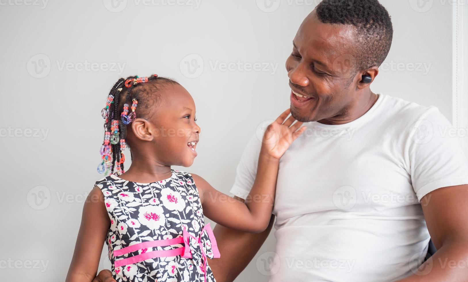 fröhlicher afroamerikanischer vater und tochter spielen im wohnzimmer, glücksfamilienkonzepte foto