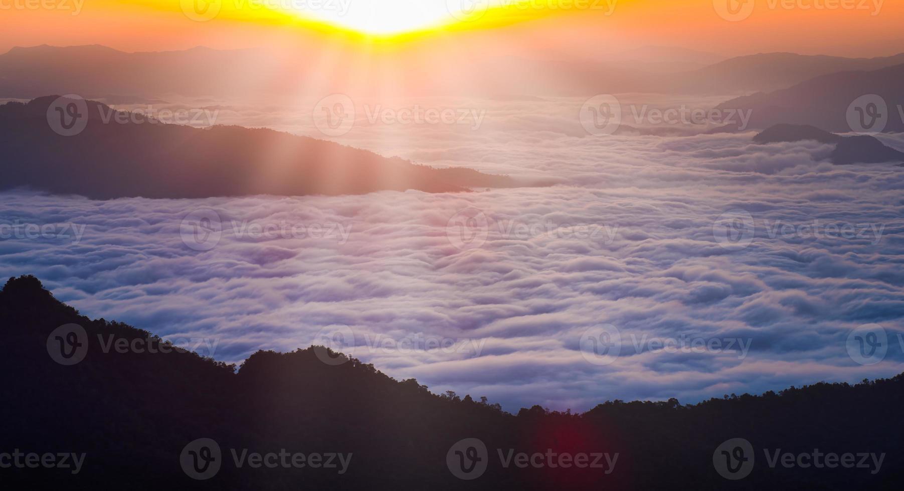 schöne landschaftsansicht des sonnenaufgangs-berggipfels mit tropischem wald im nebel. Panoramablick auf ein Bergtal in niedrigen Wolken foto