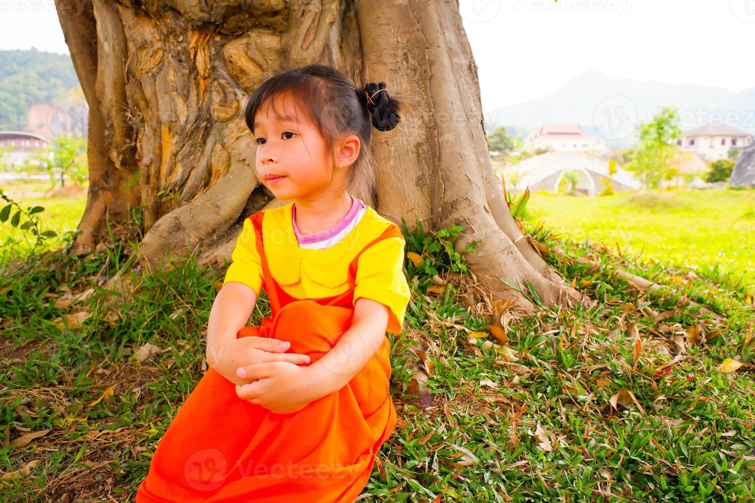 Schönes kleines Mädchen trägt gelb-orangees Outfit Gokowa-Outfit, Mugunghwa in einem öffentlichen Park. Modekleid für Mädchen und Teenager. foto