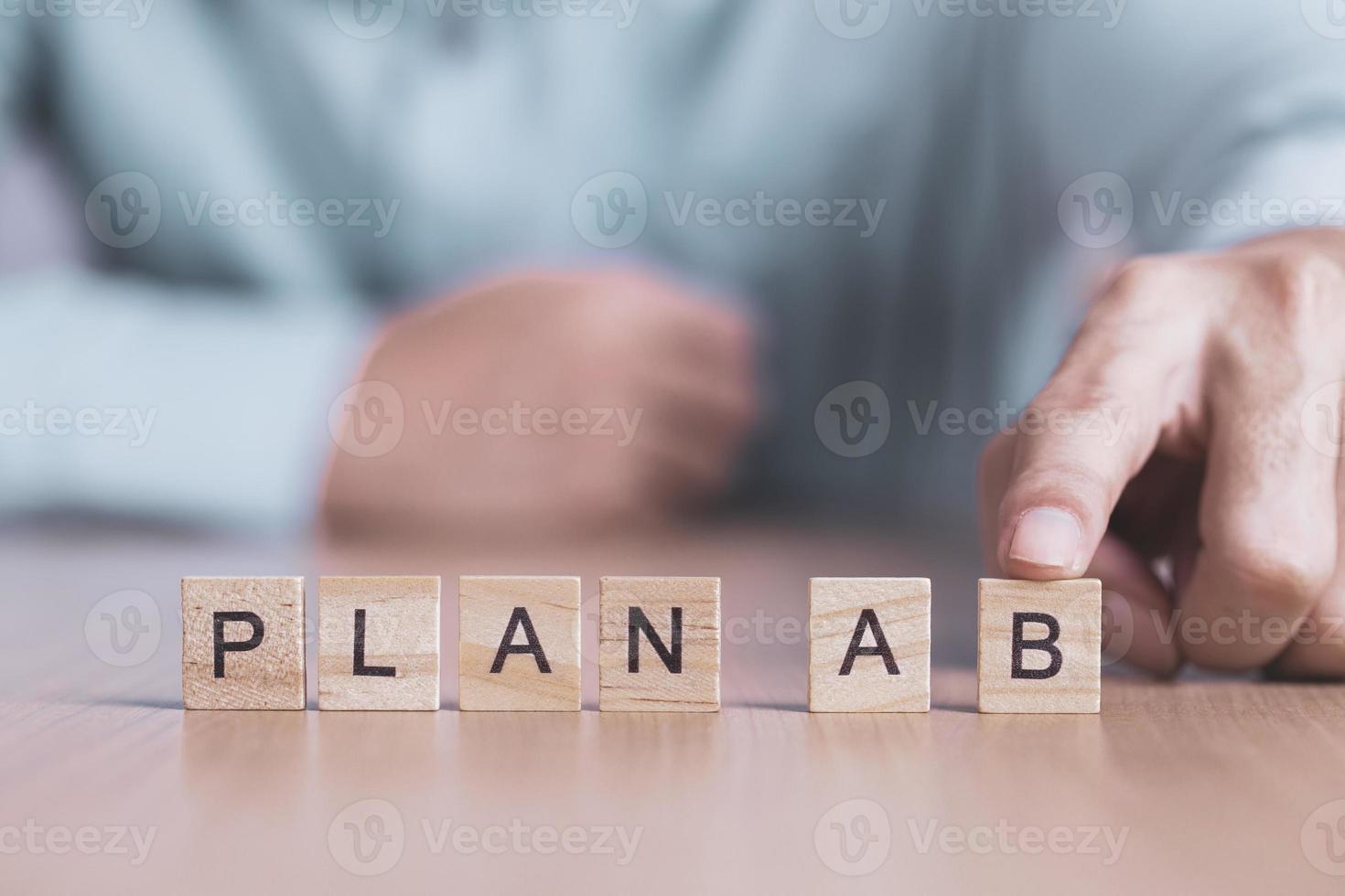 geschäftsmann wählt ein plan-b-wort auf holzblock, geschäftserfolg kreatives motivationskonzept foto