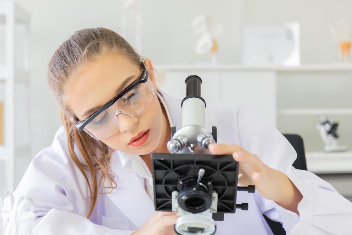 Eine schöne Wissenschaftlerin arbeitet in einem Wissenschaftslabor mit verschiedenen Geräten im Labor. foto