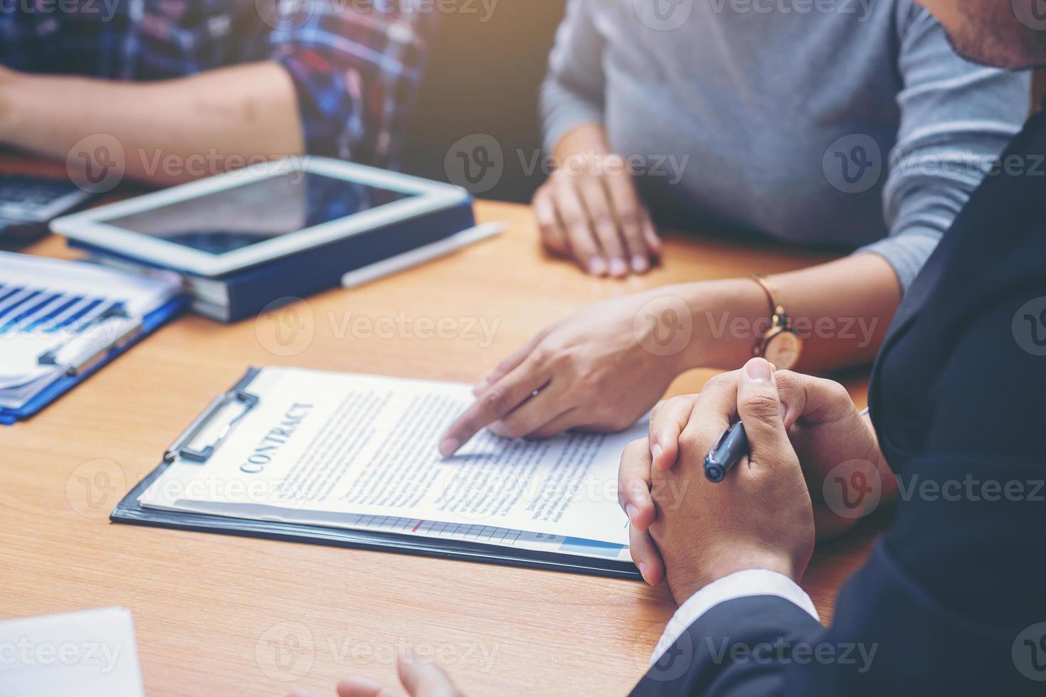 geschäftsfrau liest dokumente bei treffen, geschäftspartner erwägt vertragsbedingungen vor unterzeichnung und prüft rechtliche vertragsrechtliche bedingungen. ausgewählten Fokus foto