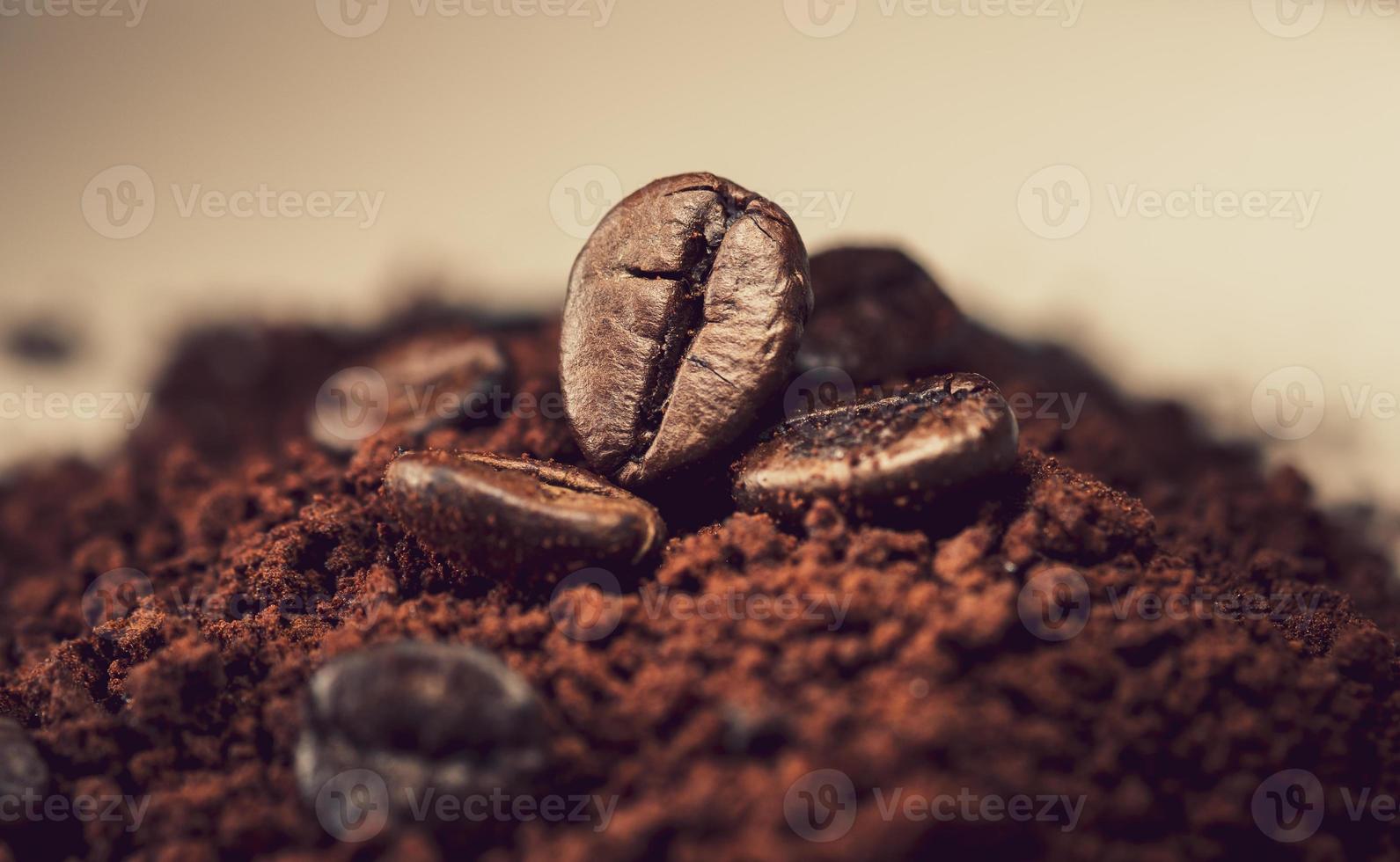 Kaffeebohnen auf einem Haufen gemahlenem Kaffeepulver foto