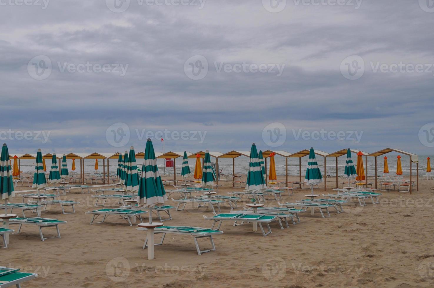 Uferstrand mit Sonnenschirm und Liegestühlen foto