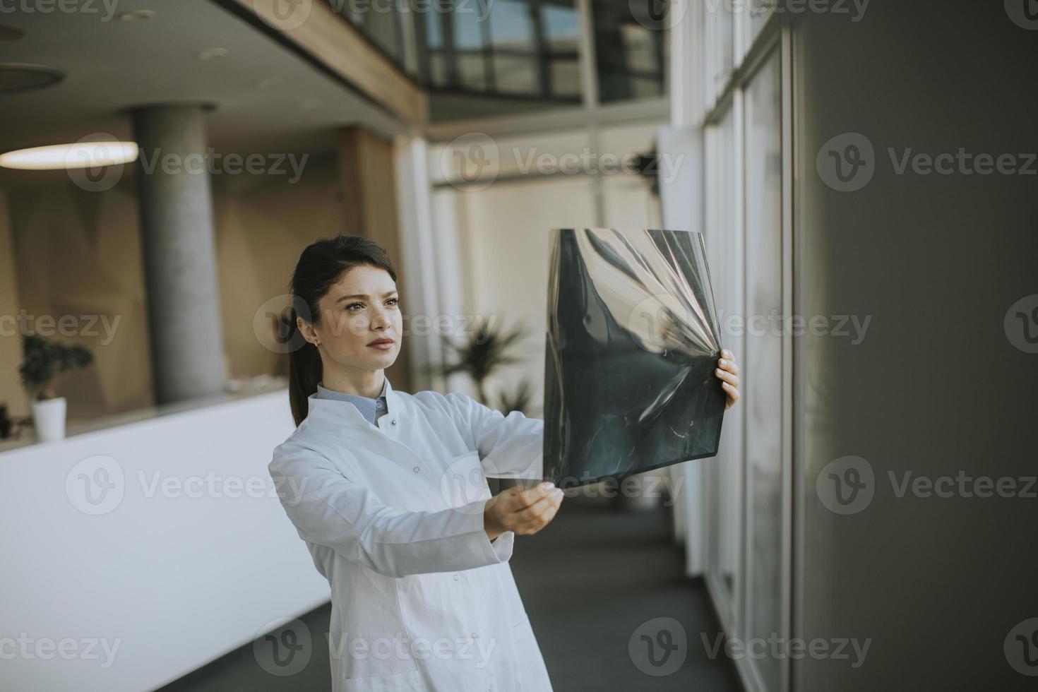 junge weibliche doctos, die röntgenbild im büro untersuchen foto