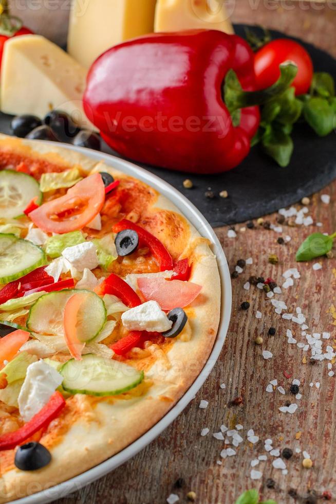 Vegetarische Pizza mit Gemüse und Zutaten auf Holzhintergrund, Nahaufnahme. gesundes Essen foto