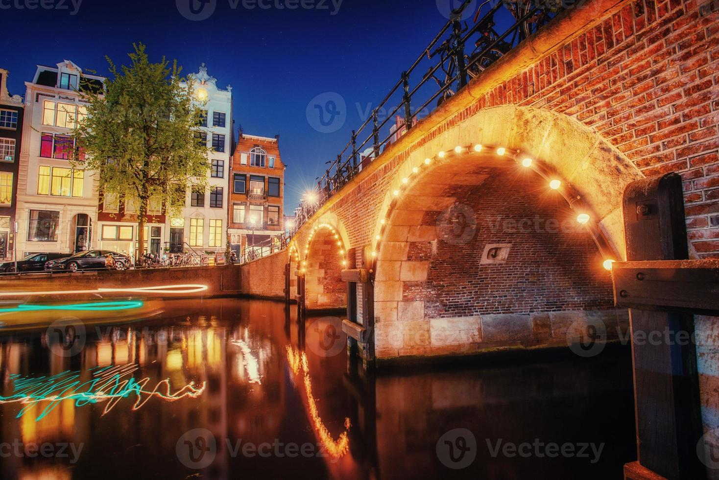 Kanal in Amsterdam bei Nacht. Hervorhebung von Gebäuden und Straßen foto