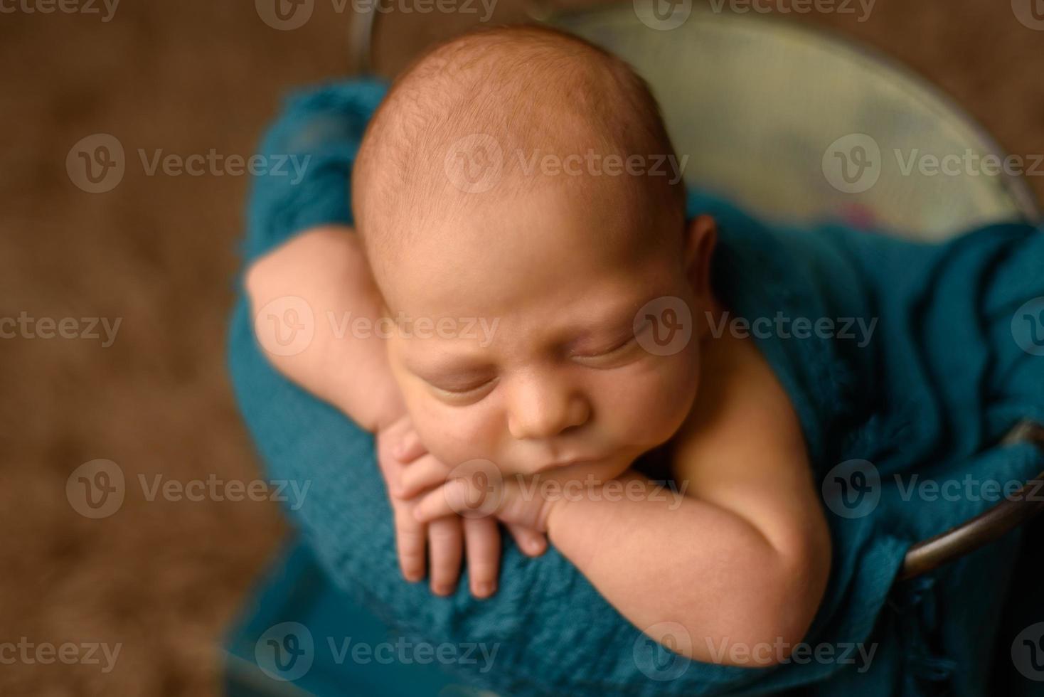 schönes neugeborenes baby, das ihre hände auf ihrem gesicht ruht foto