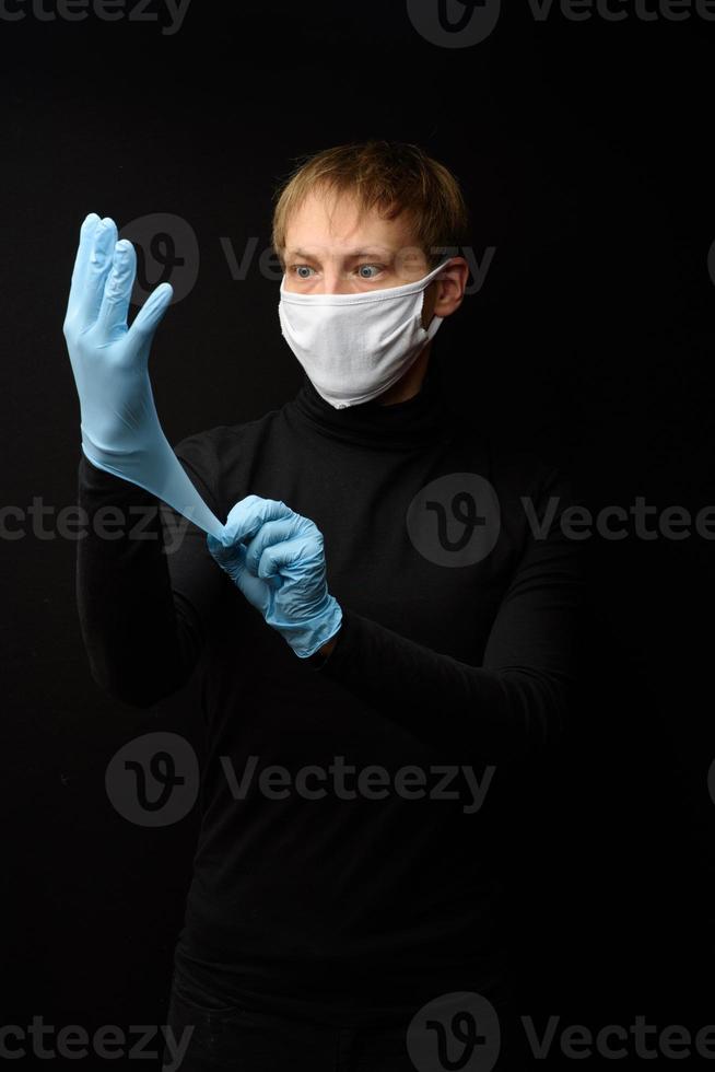 Arzt mit Latex-Schutzhandschuhen und Gesichtsmaske. Vorderansicht des Gesichts des Mannes mit einer medizinischen Maske. coronavirus covid-19 und gesundheitskonzept foto