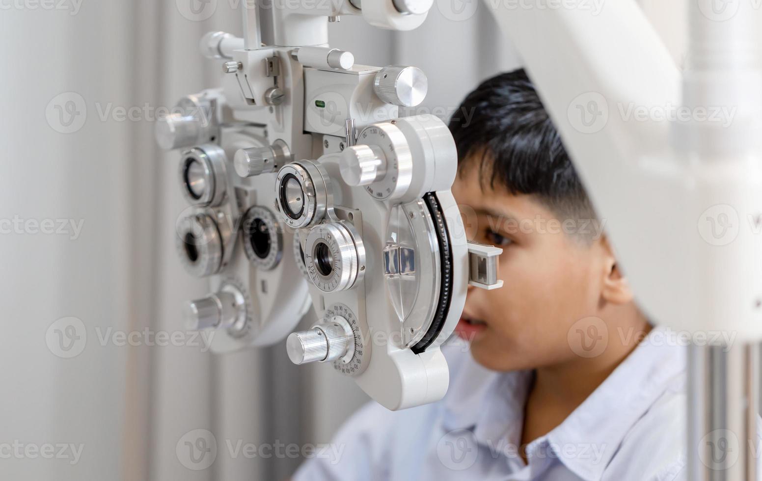 Junge, der Sehtests mit Optiker im Optikgeschäft durchführt, Optiker, der Sehtests für Kinderpatienten in der Klinik durchführt foto