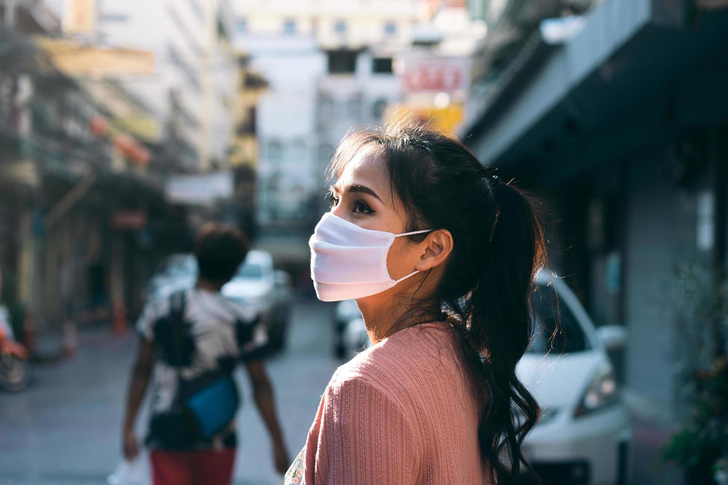 asiatische erwachsene frau tan haut tragen maske auf gesicht für neue normalität. foto