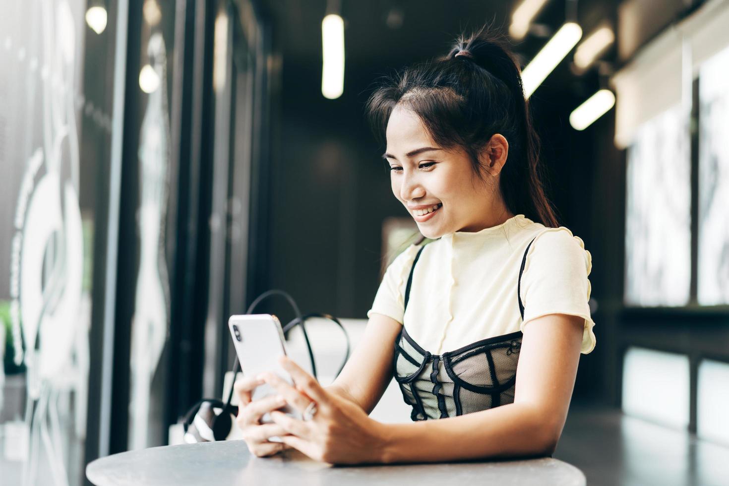 Junge asiatische Geschäftsfrau mit Handy für Online-Dating-App im Büro foto