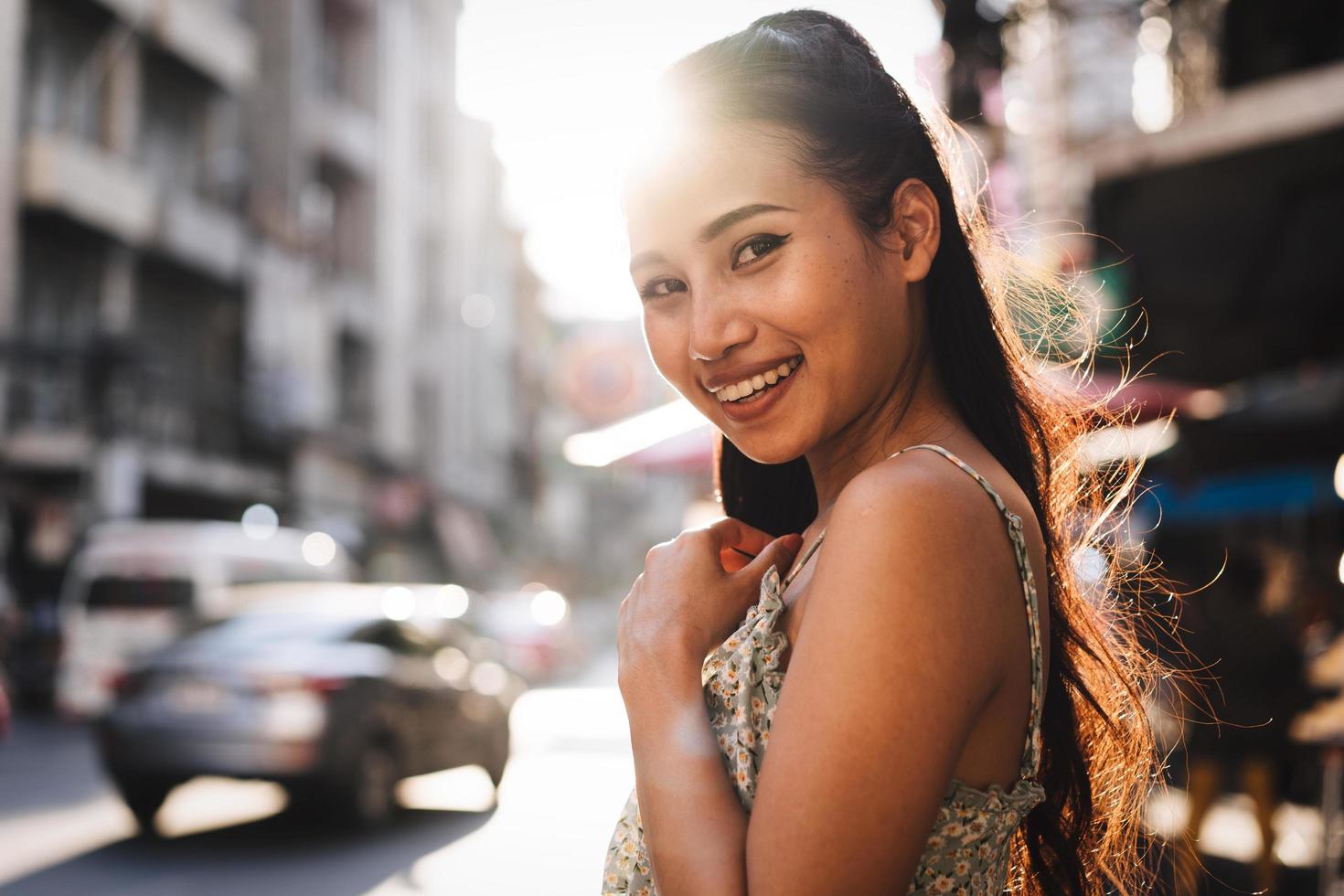 Porträt einer jungen erwachsenen asiatischen Frau mit glücklichem Lächeln im Freien am Tag foto