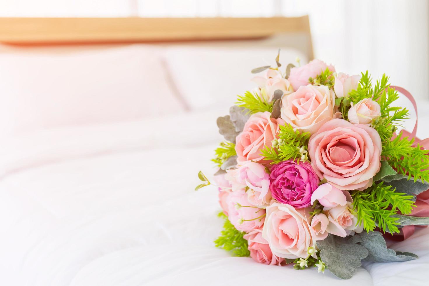 Sehr schöner Blumenstrauß auf einem sauberen weißen Bett. foto
