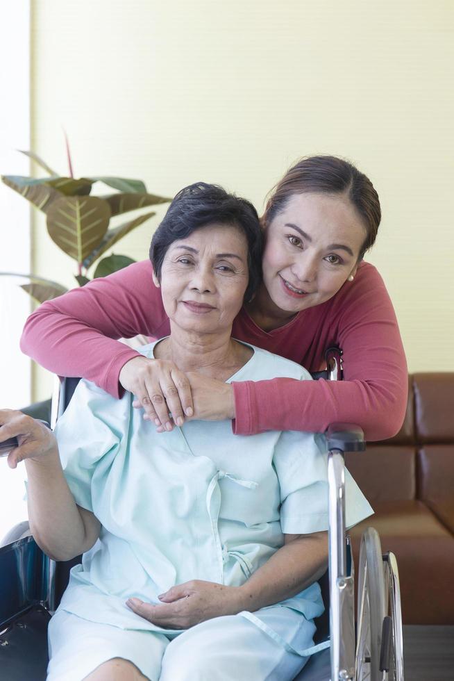 Eine ältere asiatische Mutter, die eine Tochter hat, kümmert sich liebevoll in einem speziellen Krankenzimmer um sie. foto