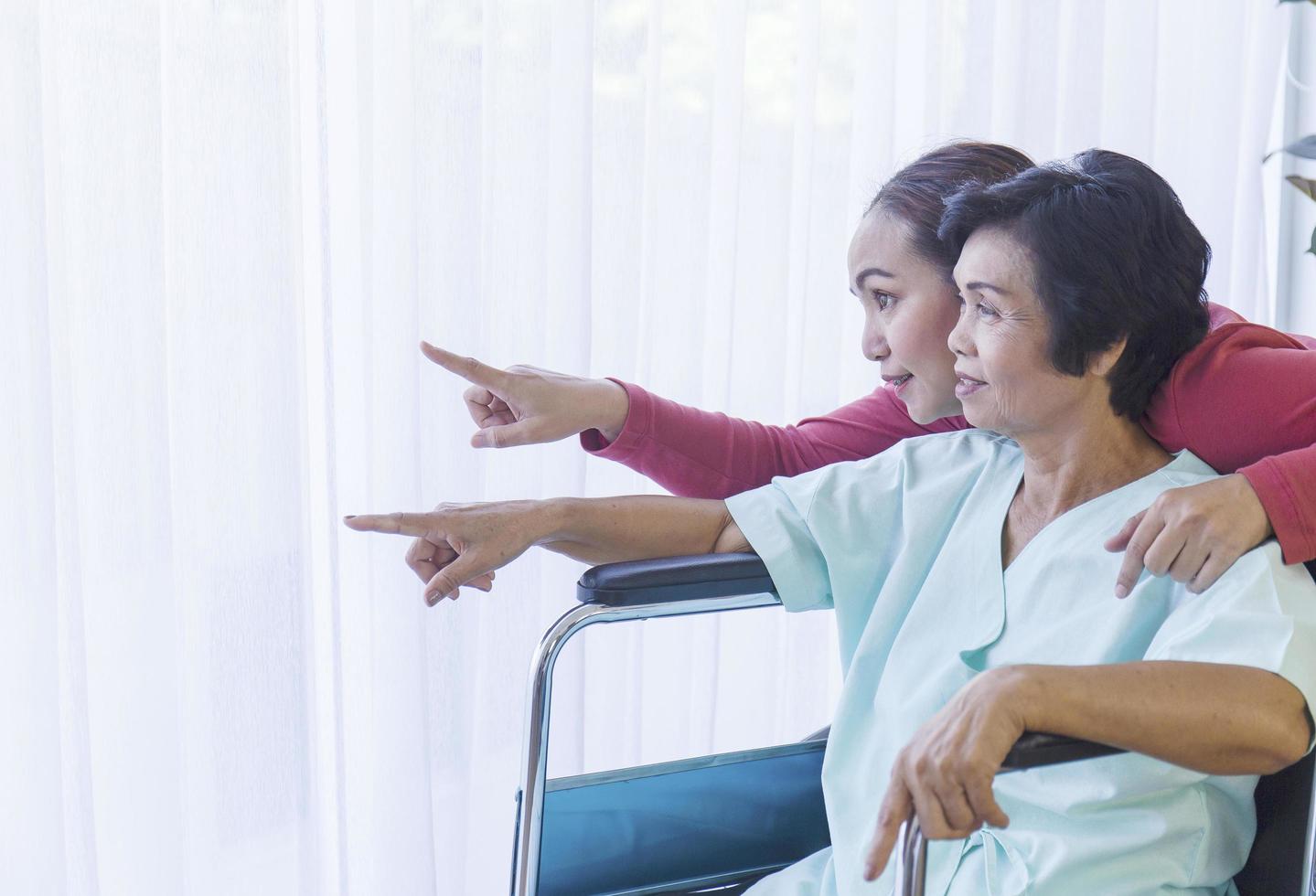 die asiatische familie, eine kranke mutter, sitzt im rollstuhl, liegt im krankenhaus und hat eine tochter zu versorgen. foto