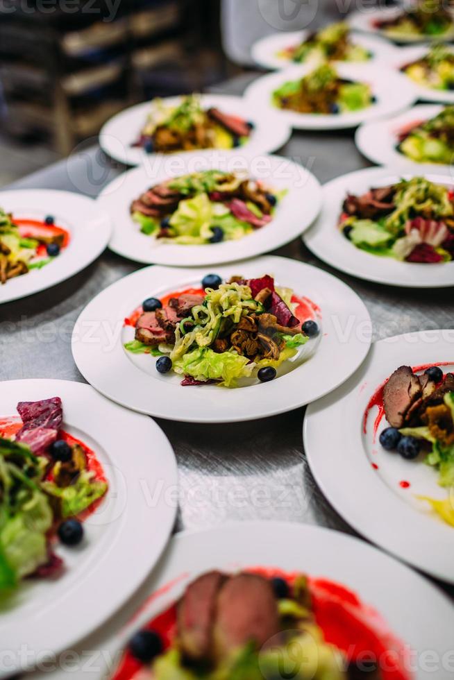 Fleischgericht mit Gemüse für die Gastronomie. viele Teller. foto