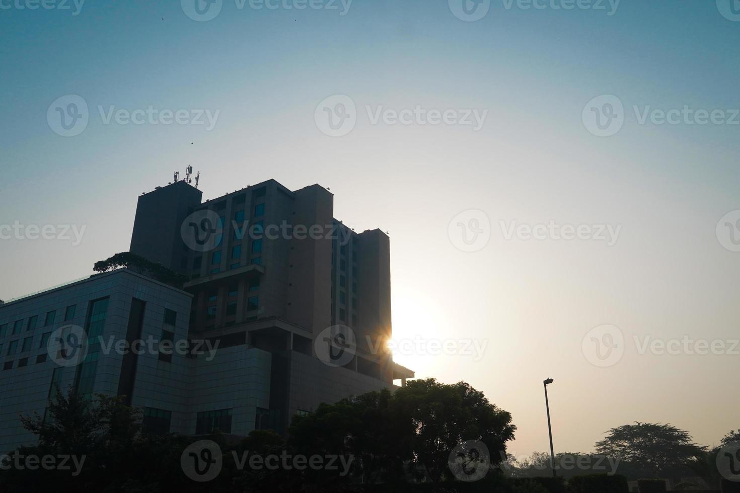 modernes Glasgebäude mit reflektierter Abendstadt und Sonnenuntergangshimmel darin. foto