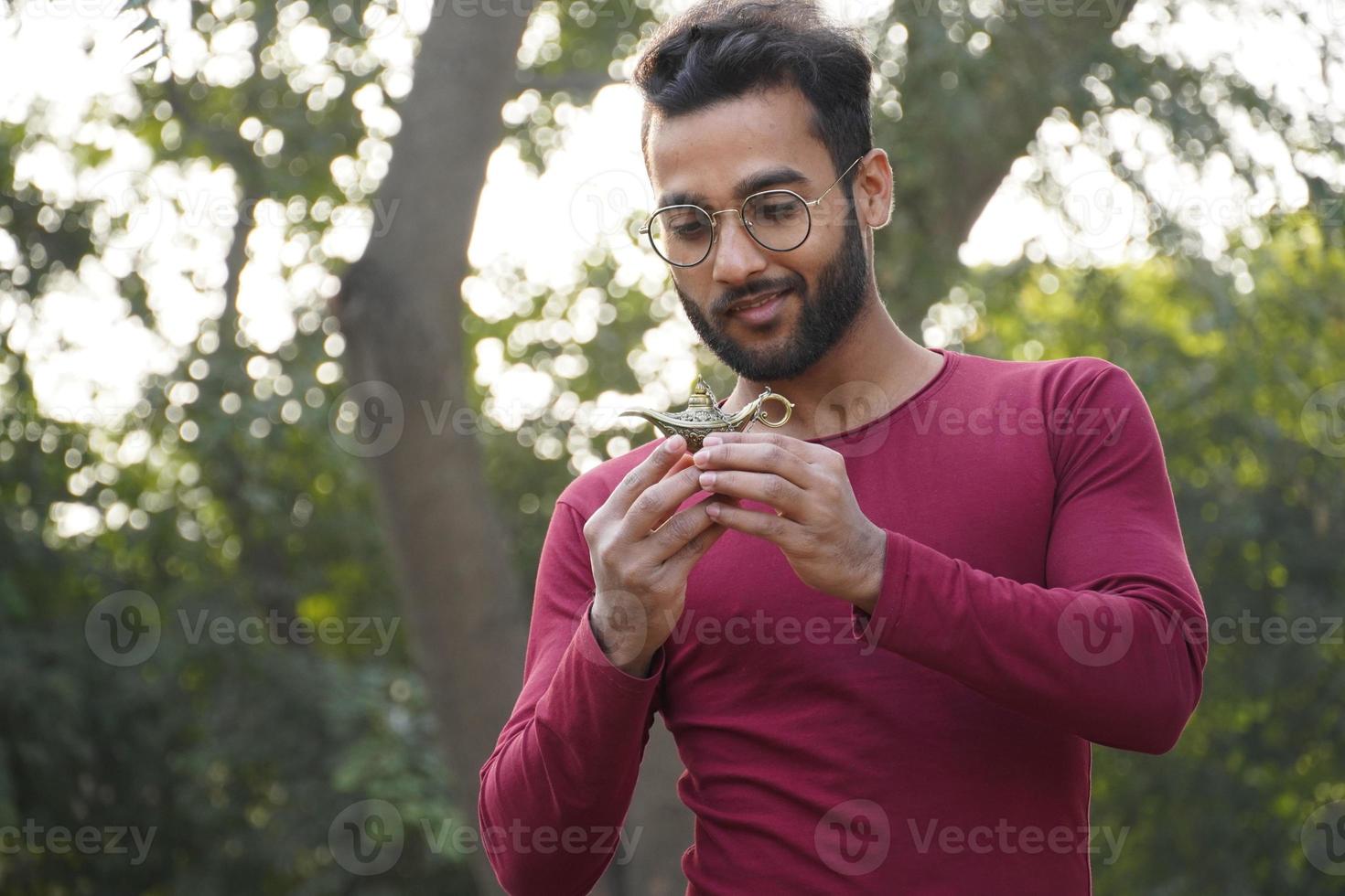 Ein Junge hat eine Aladdin-Lampe in der Hand, während er die Lampe ansah foto