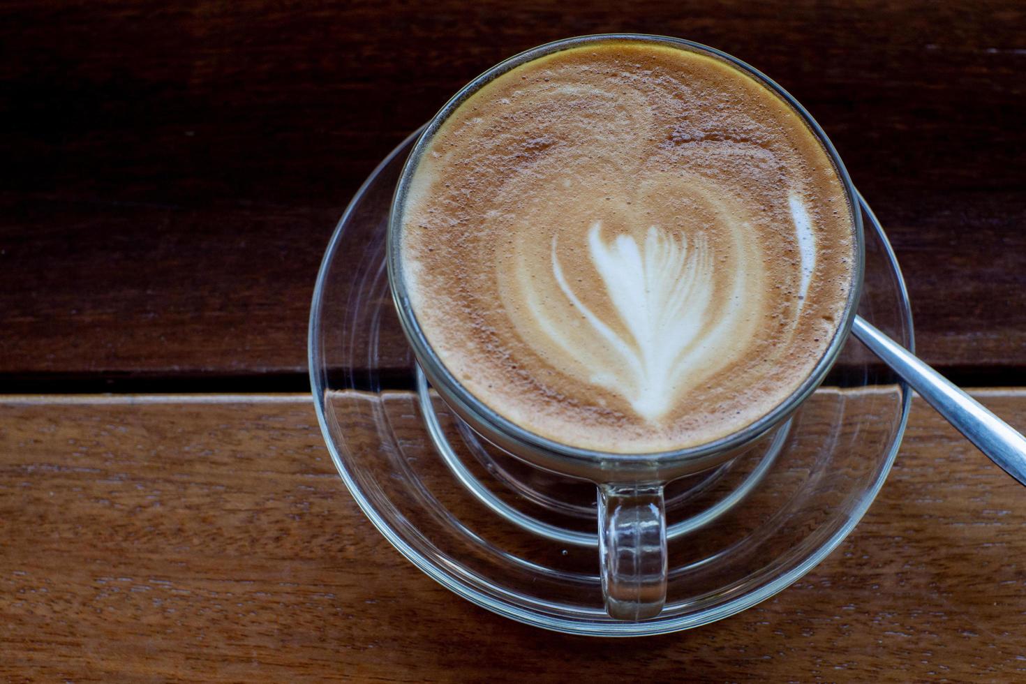 Cappuccino-Kaffee auf altem Holztisch und gerösteten Kaffeebohnen - Bild foto