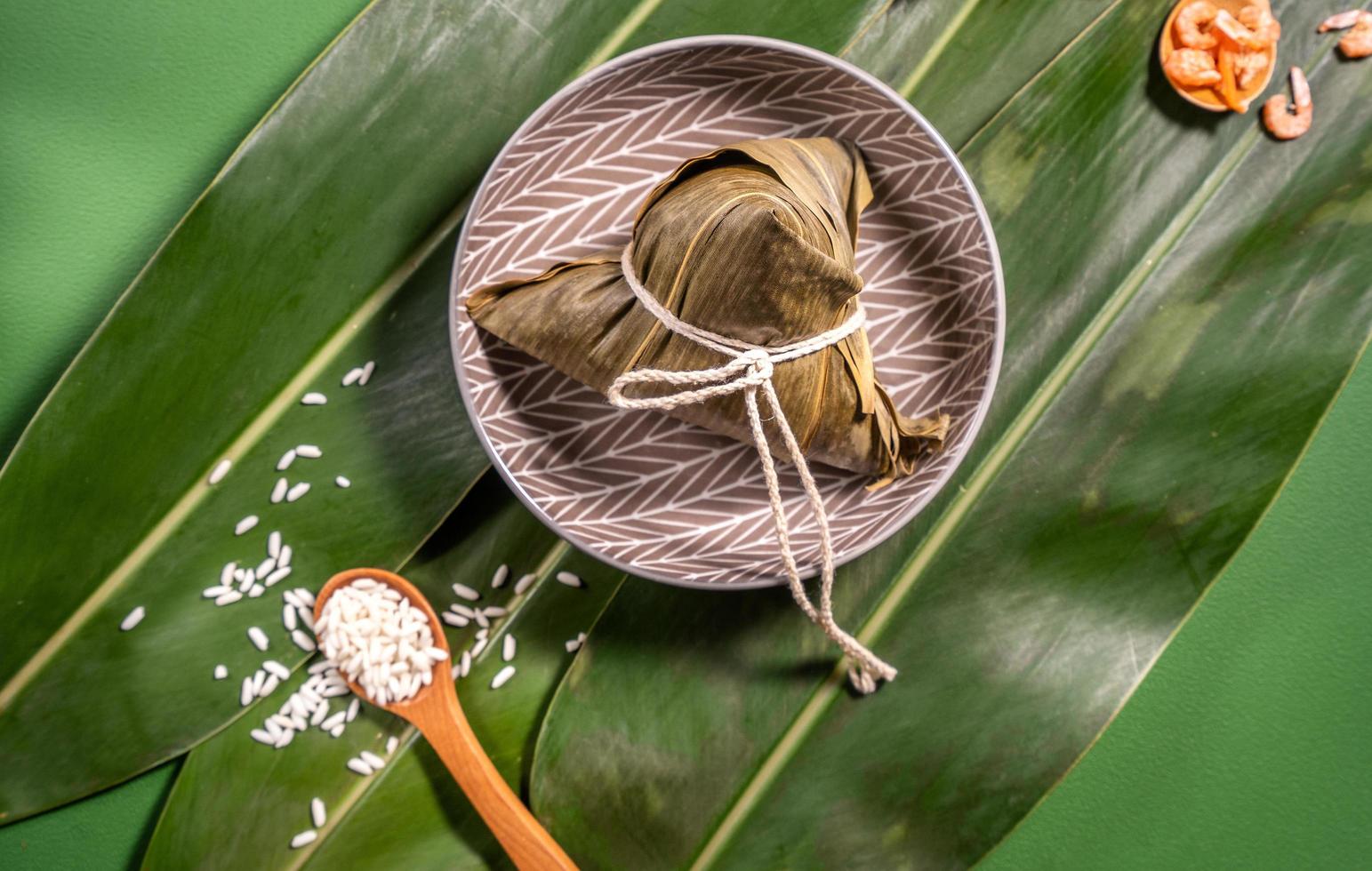 Zongzi, gedämpfte Reisknödel auf grünem Tischhintergrund, Essen im Drachenbootfestival Duanwu-Konzept, Nahaufnahme, Kopierraum, Draufsicht, flache Lage foto