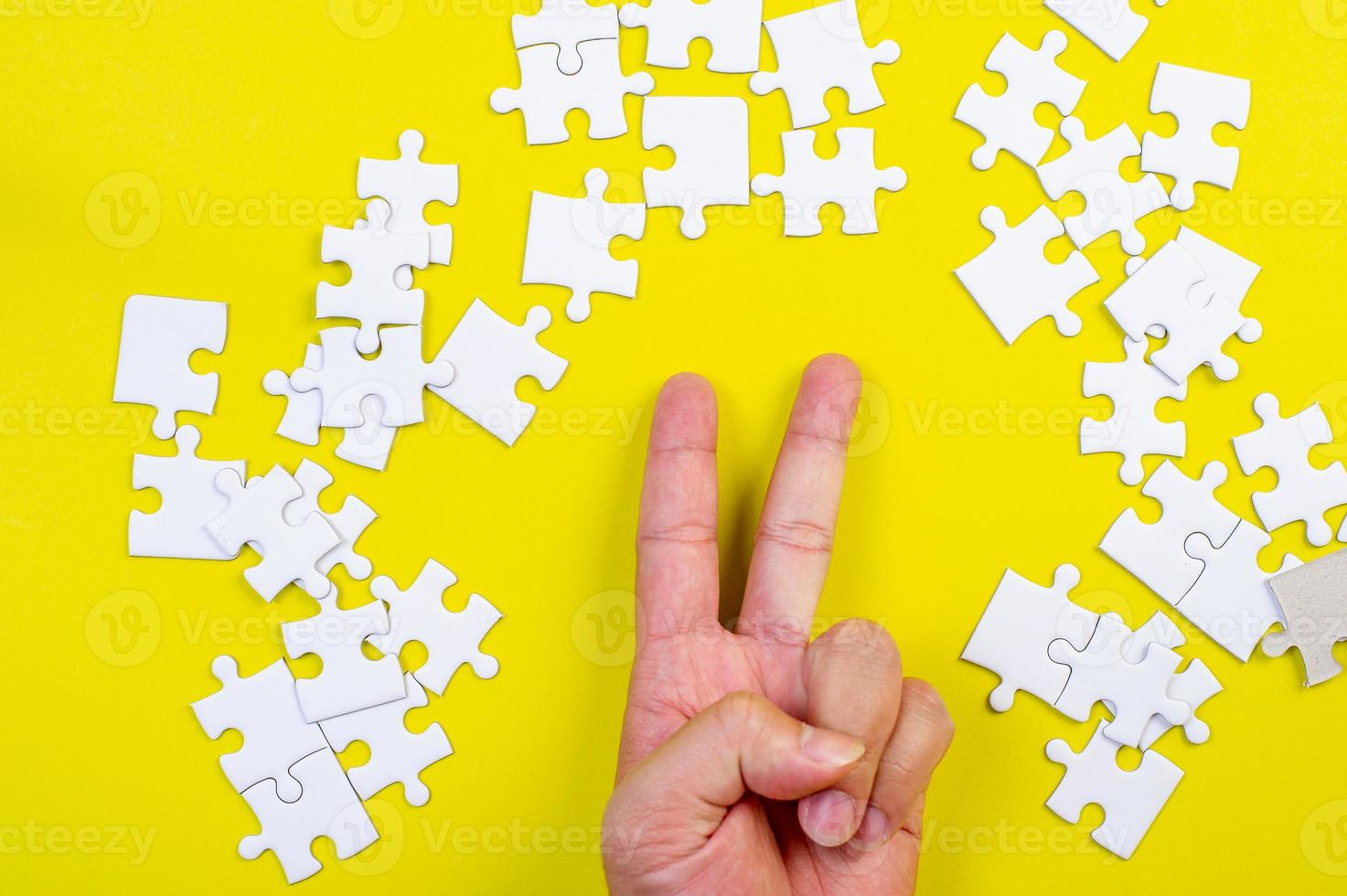 Puzzle und Hände auf dem gelben Konzepthintergrund foto