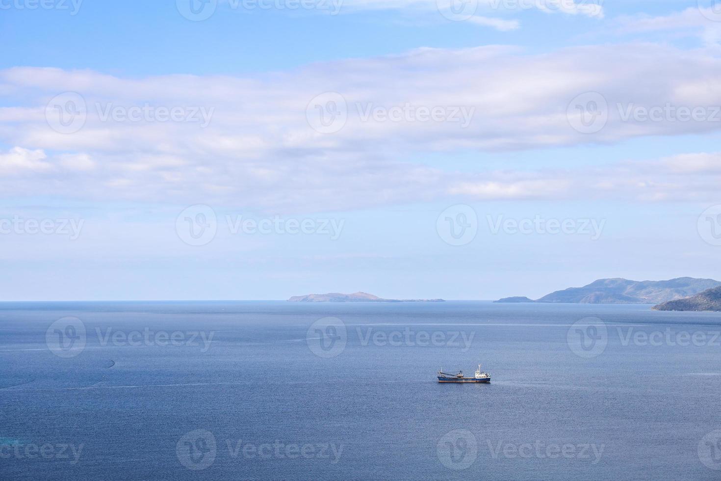 Meereshintergrund mit Fischerboot, das unter blauem Himmel segelt foto