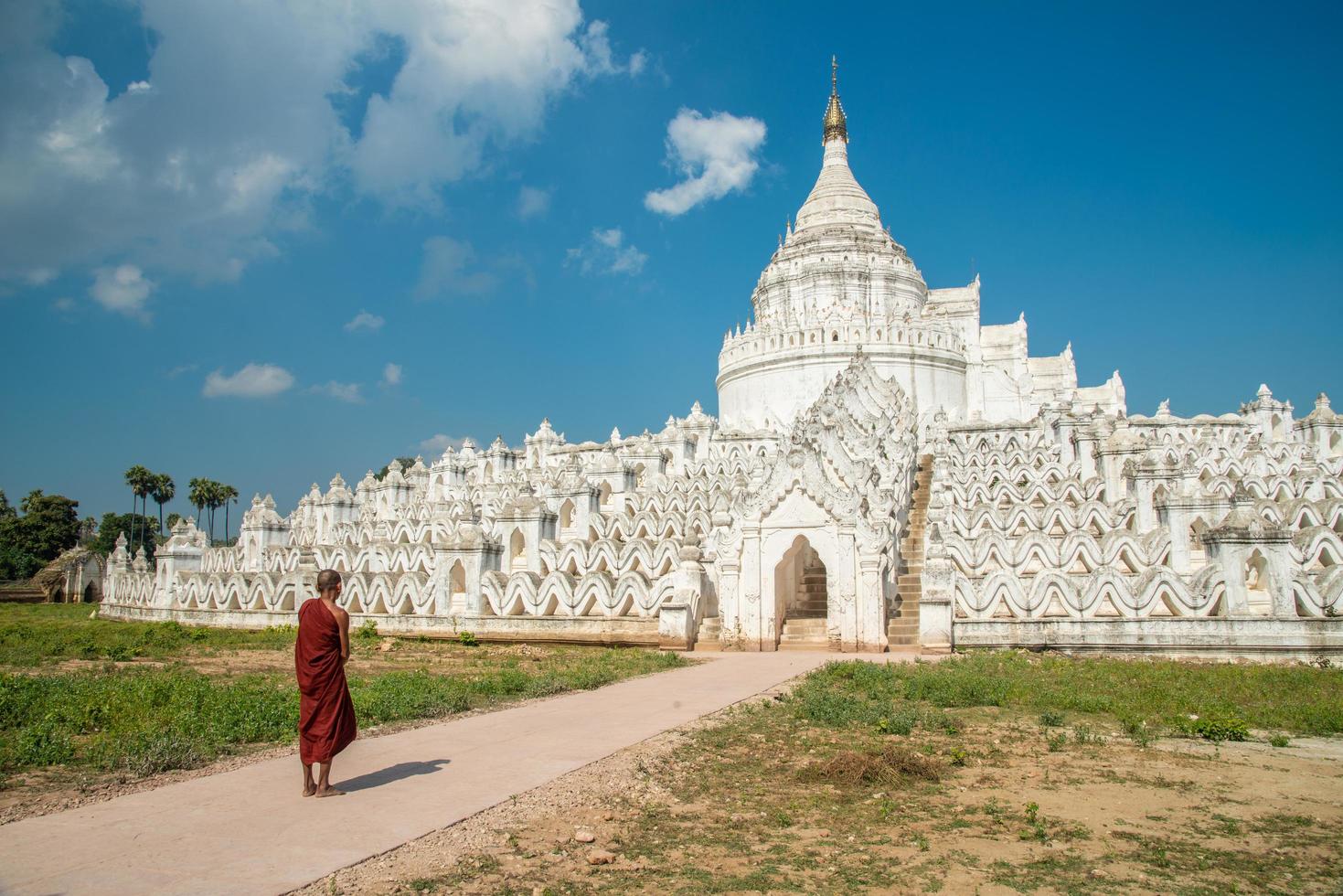birmanischer Mönch, der vor der Hsinbyume-Pagode steht, ein anderer Name namens 'Taj Mahal des Irrawaddy-Flusses'. diese pagode, die den berg meru der buddhistischen kosmologie darstellt, befindet sich in der sagaing-region von myanmar. foto
