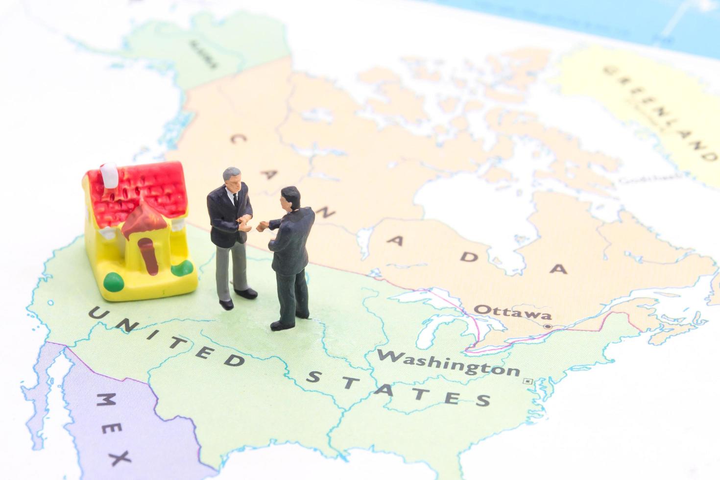 Geschäftsmann und Haus auf Karte amerikanisch. Miniaturmenschen foto