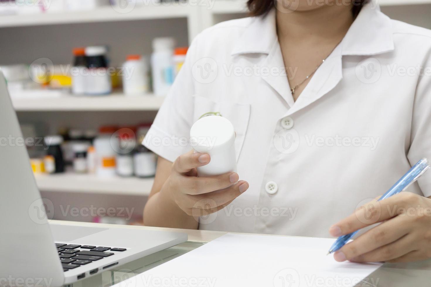 Apotheker mit Laptop-Computer und Medikamenten in der Apotheke foto