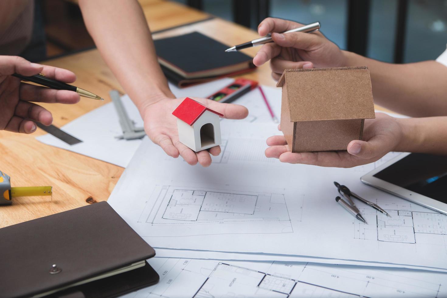 team von architekten oder ingenieuren, die auf dem schreibtisch mit entwurf über ein neues startprojekt auf dem schreibtisch diskutieren. teamgruppe auf der baustelle überprüfen sie dokumente und geschäftsabläufe. selektive fokussierung. foto