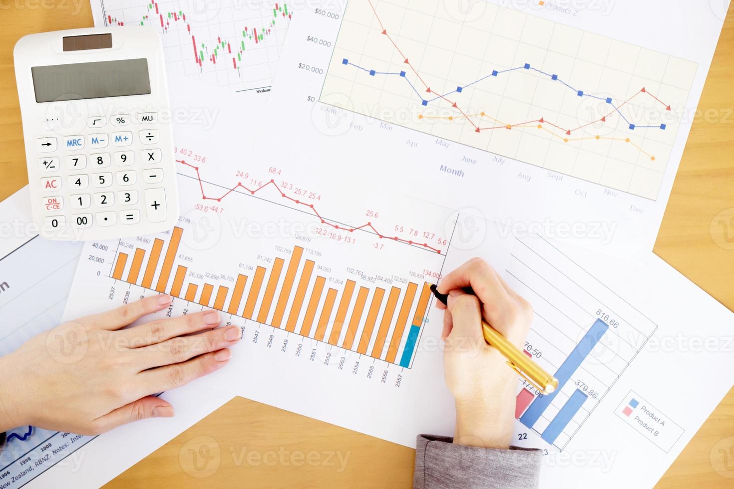 geschäftsfrau, die bericht über diagramm mit taschenrechner analysiert foto