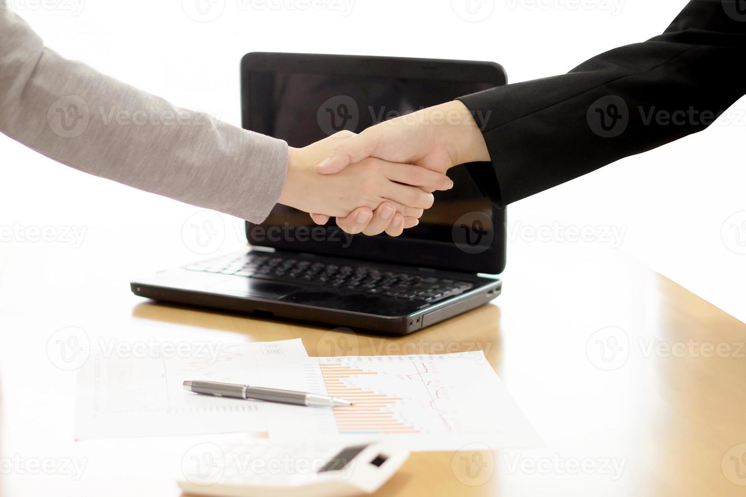 Zwei Geschäftsleute geben sich drinnen die Hand foto