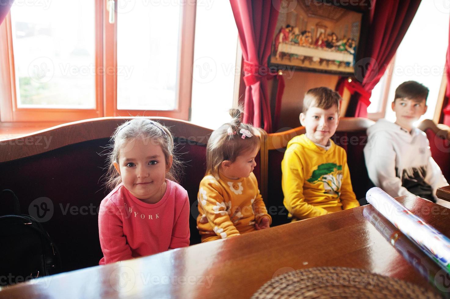 Kinder an Geburtstagen sitzen am Tisch. foto