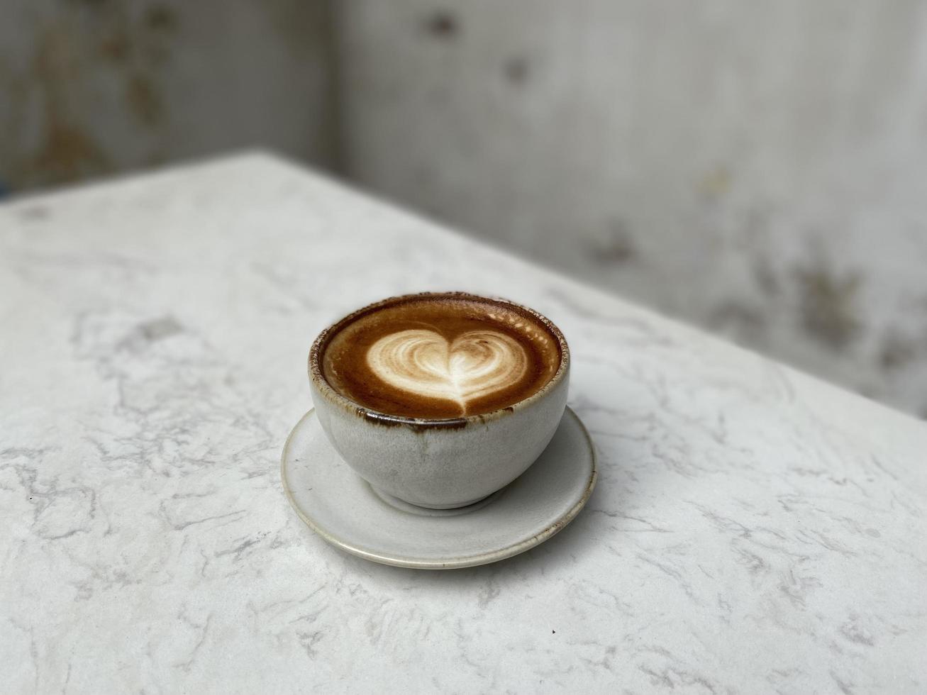 Herz Latte Art auf Kaffeetasse auf Holztisch foto