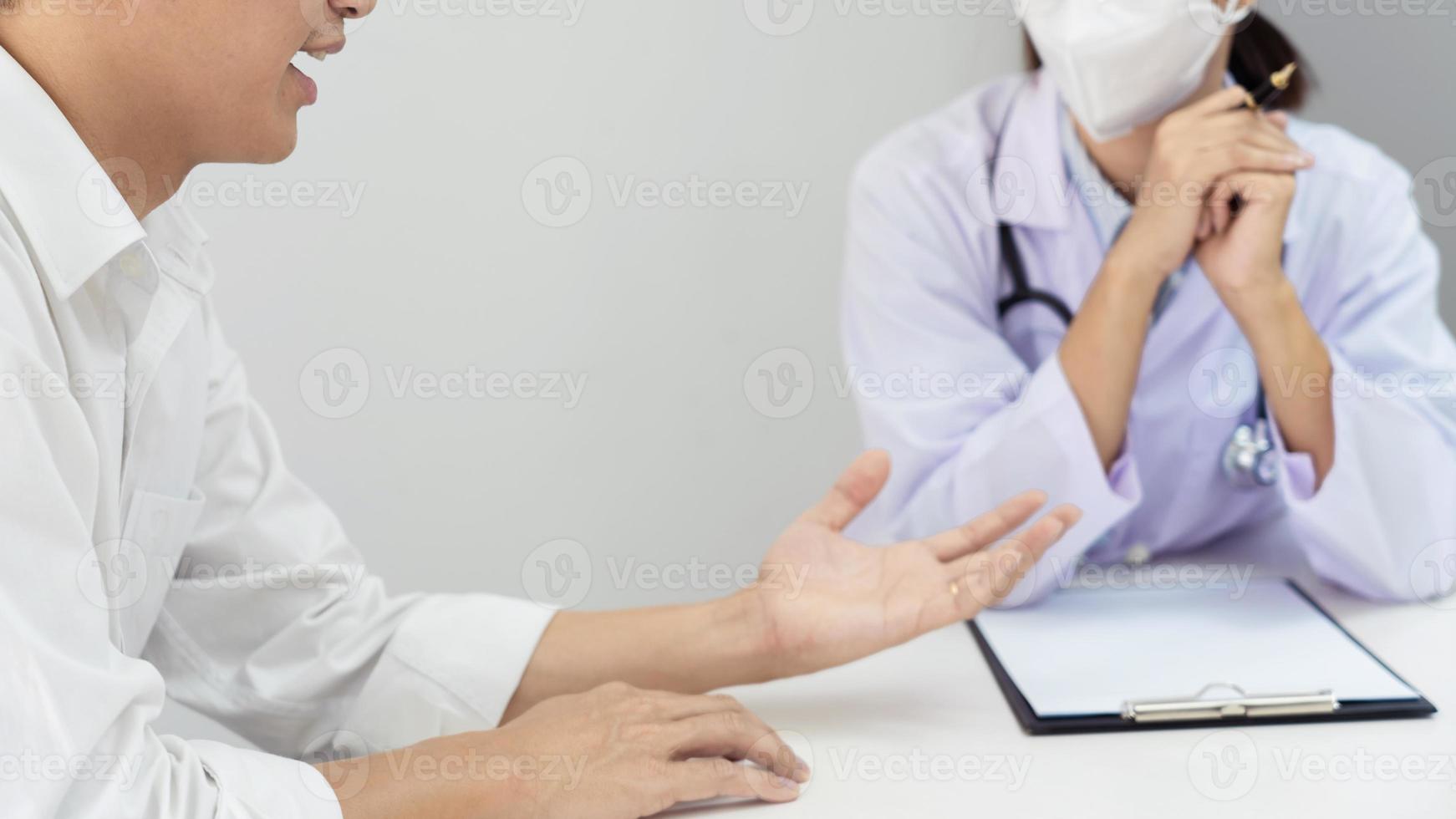 patient hört aufmerksam dem arzt zu, der die symptome erklärt, medizinische informationen, vorbeugung, krankheiten und diagnose, in einer medizinischen klinik oder einem gesundheitsdienstzentrum eines krankenhauses. foto