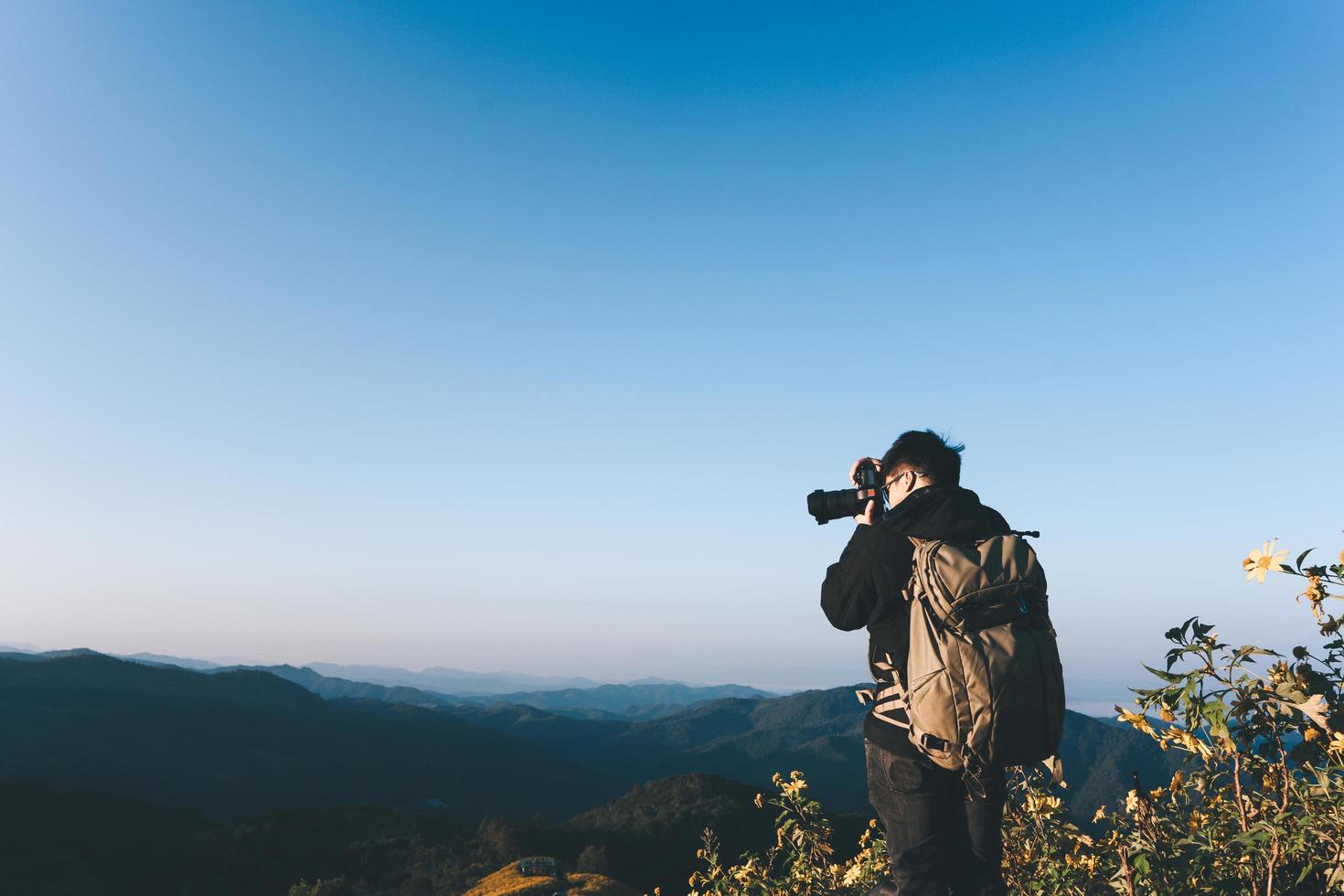 Rucksack asiatischer erwachsener männlicher Fotograf am Berg. Schlucht . foto