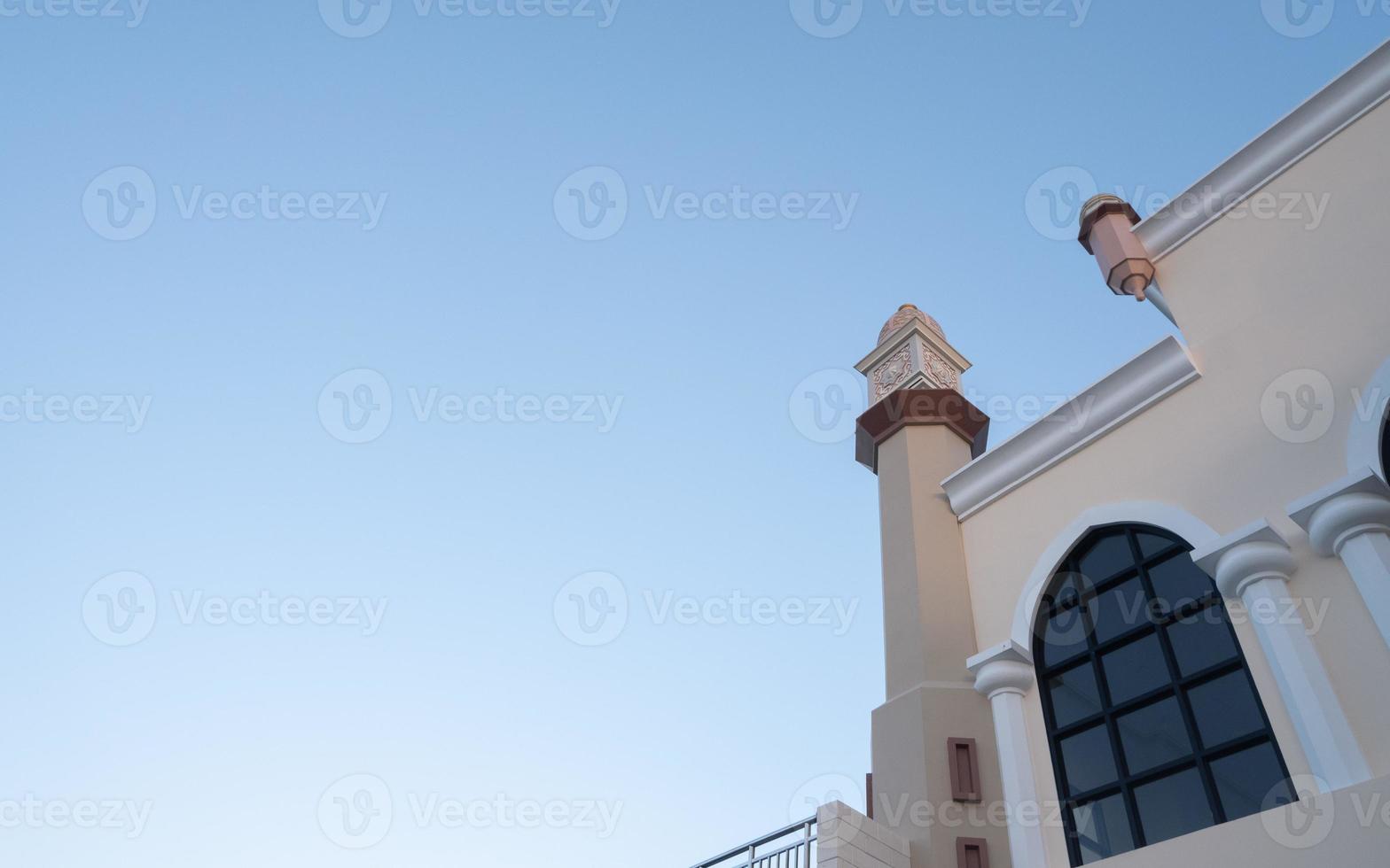 Blick auf das Moscheegebäude mit Minarett und blauem Himmelshintergrund. Architektur-, Innen- und Turmdetails foto