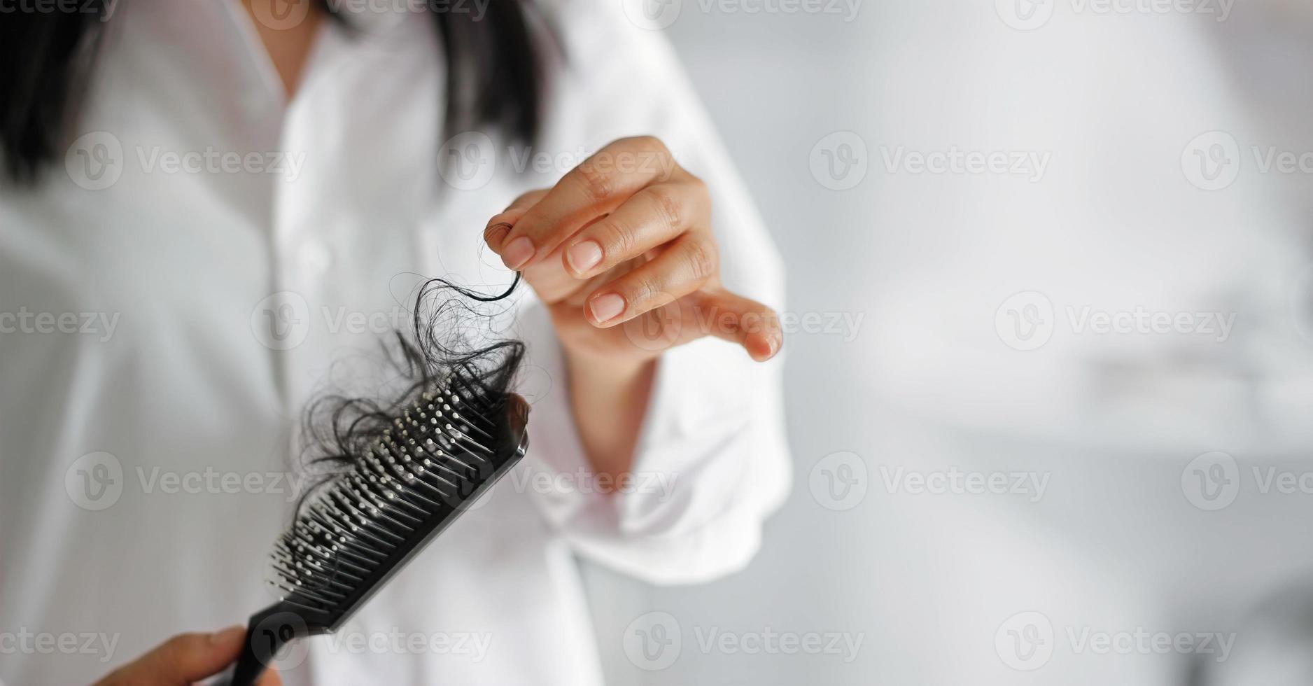 Frau verliert Haare auf Haarbürste in der Hand, weicher Fokus foto