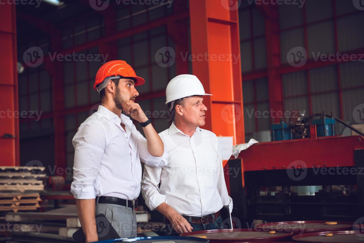 fabrikarbeitervorarbeiter und ingenieurmanager, der auf einer industriebaustelle zusammenarbeitet und aus sicherheitsgründen einen harten hut trägt foto