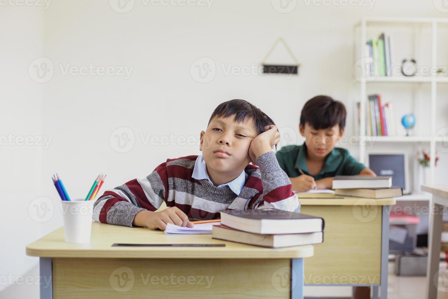 fauler Schüler während einer Unterrichtsstunde in einem Klassenzimmer foto