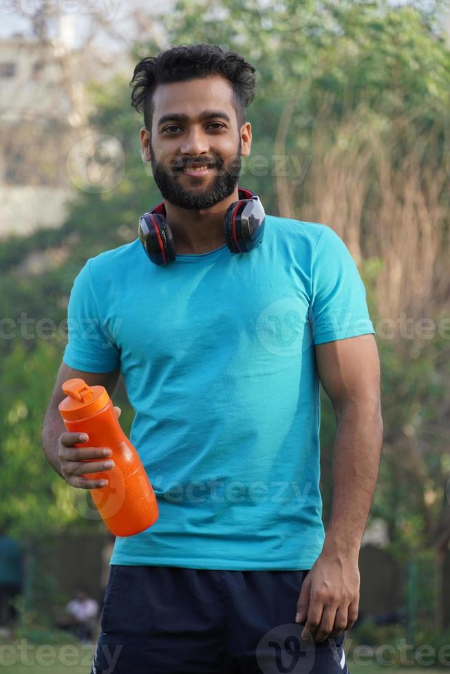 Gesunder Mann mit Proteingetränk im Shaker am Morgen im Park foto
