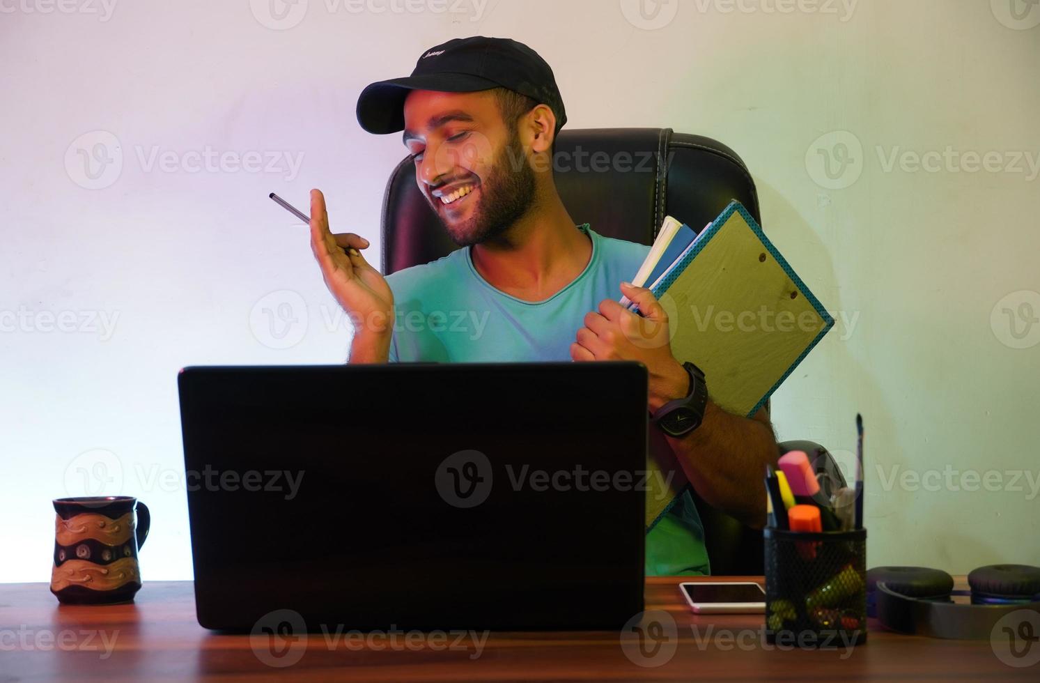 ein Student, der mit Laptop lächelt und sitzt foto