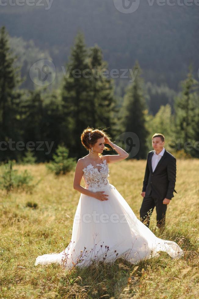 Hochzeitsfotografie in den Bergen. Braut und Bräutigam umarmen sich fest. foto
