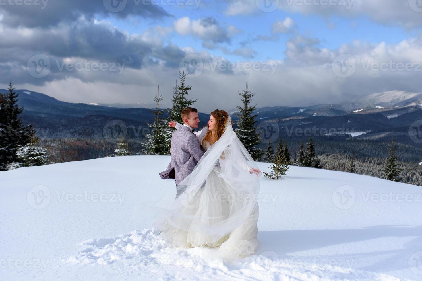 der bräutigam führt seine braut an der hand zu einer einsamen alten buche. Winterhochzeit. Platz für ein Logo. foto