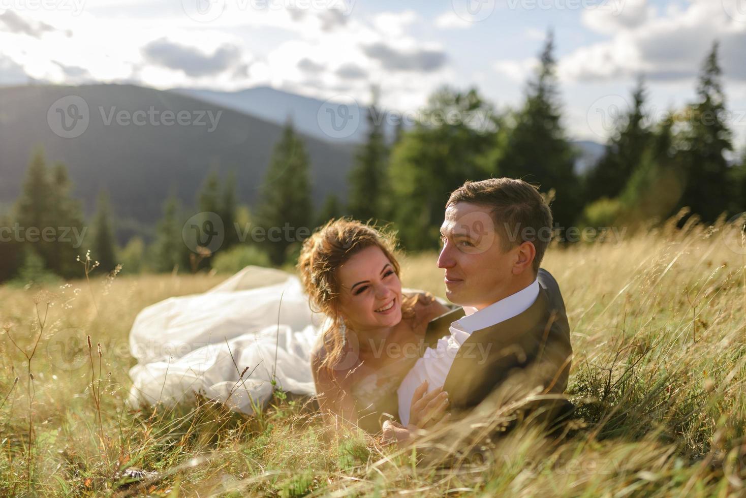 Hochzeitsfotografie in den Bergen. Braut und Bräutigam umarmen sich fest. foto