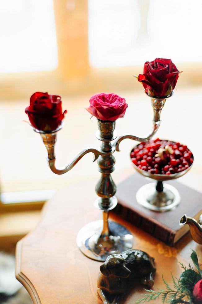 Rosen auf einem Tisch in Kerzenständern foto